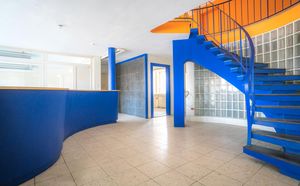 Foto vom Empfangsbereich mit blauer Wendeltreppe ins Obergeschoss